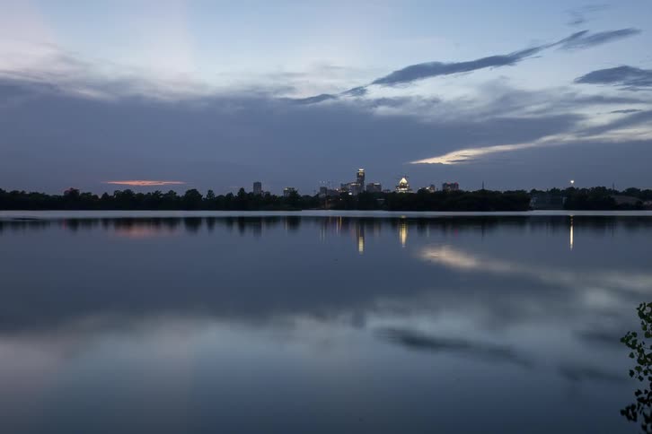 A city sits over the water at sunset