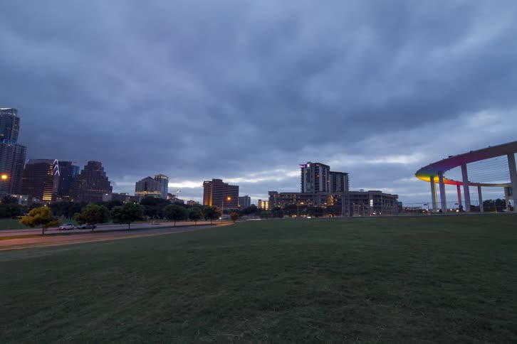 Clouds pass over a cityscape as the day breaks