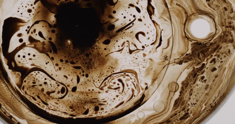 Oil and water swirl in a container
