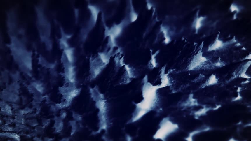 Light shines on points stretching from a surface as they move and bend in the shadows