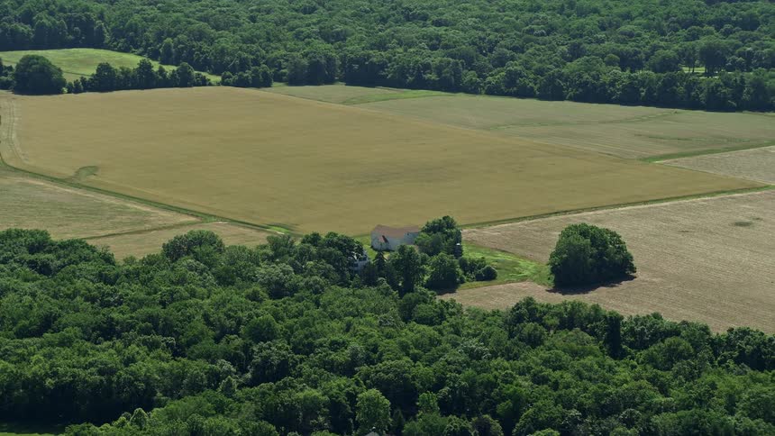 This is a aerial video clip of a rustic farmhouse surrounded by lush fields in Lawrenceville New Jersey on a sunny day
