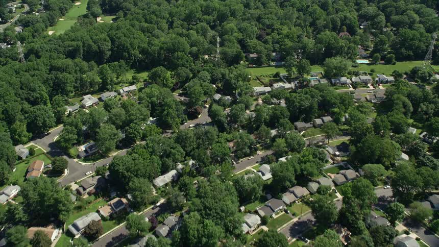 An aerial view of suburban neighborhoods surrounded by lush green vegetation in Lawrenceville New Jersey on a sunny day