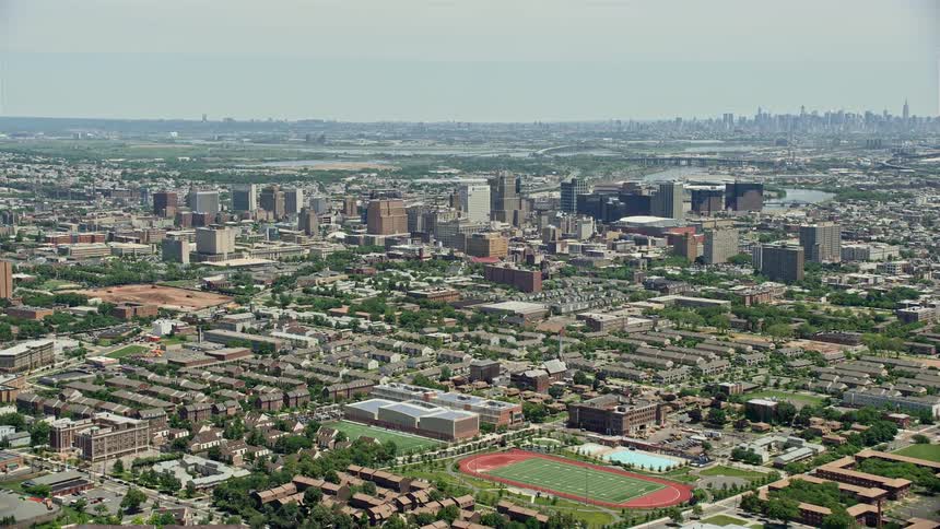 Approaching the majestic Downtown Newark cityscape with high rise buildings and towers during a sunny summer day