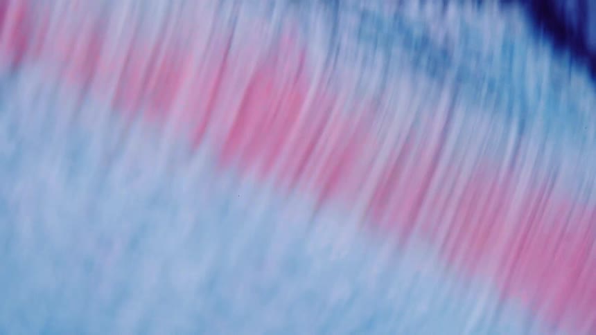 Close up of abstract light blue and red liquid flowing