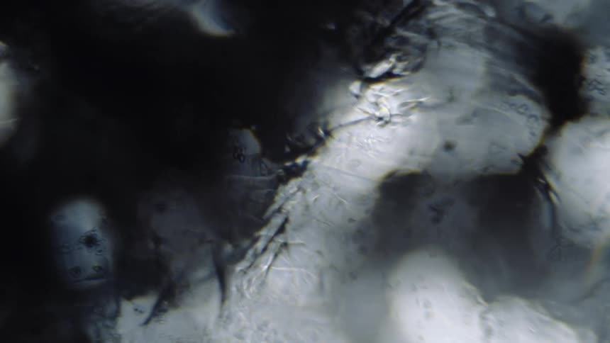 Liquid and particles move from top left corner to bottom right over shadows and light