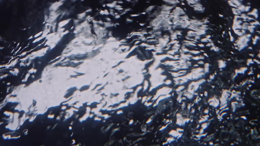 Light reflects on the ripples in the water as it swirls and moves
