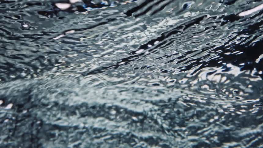 The surface of flowing rippling water