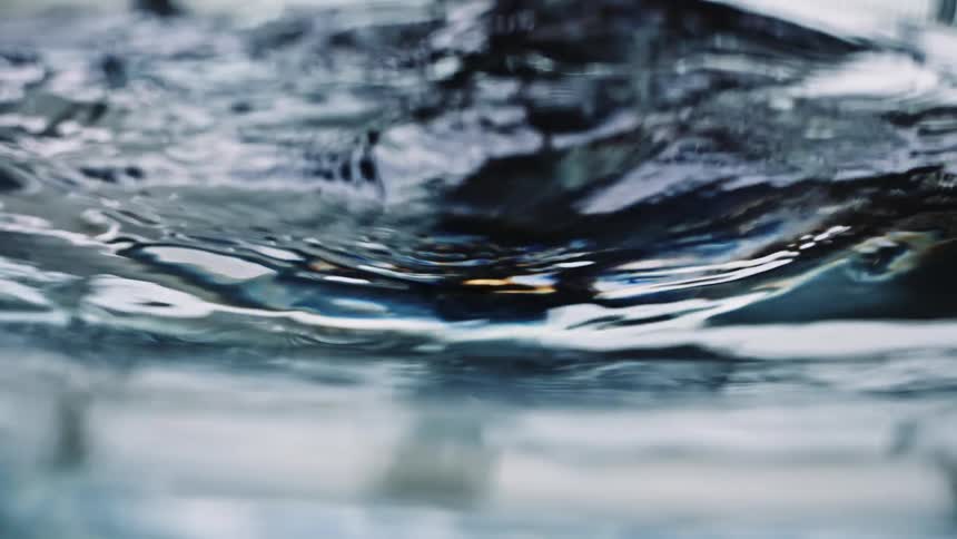Light reflects on the ripples in the water as it swirls and moves