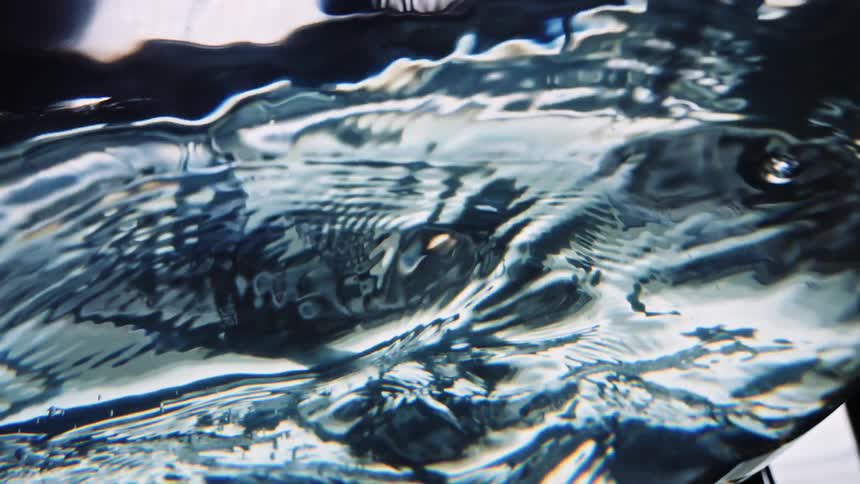 Light and textures reflect on water as it ripples and moves