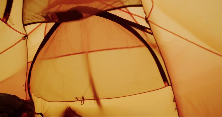 The inside of an orange tent on an extremely windy and stormy day on Baffin Island as a polar storm rolls in