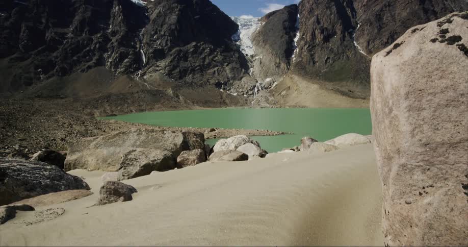 Going from sand sediment ground to sky an icecapped glacier mountain is revealed