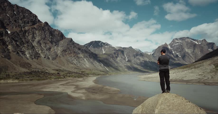 Man stares at a glacial mountain range on Baffin Island