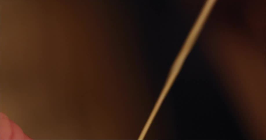 A person putting thread through a needle