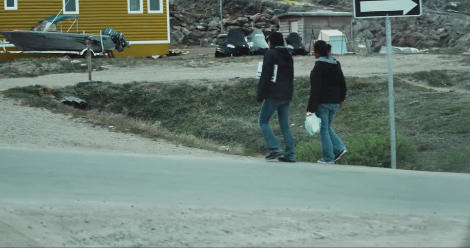 Two people walk down the small road near Iqaluit, Baffin Island