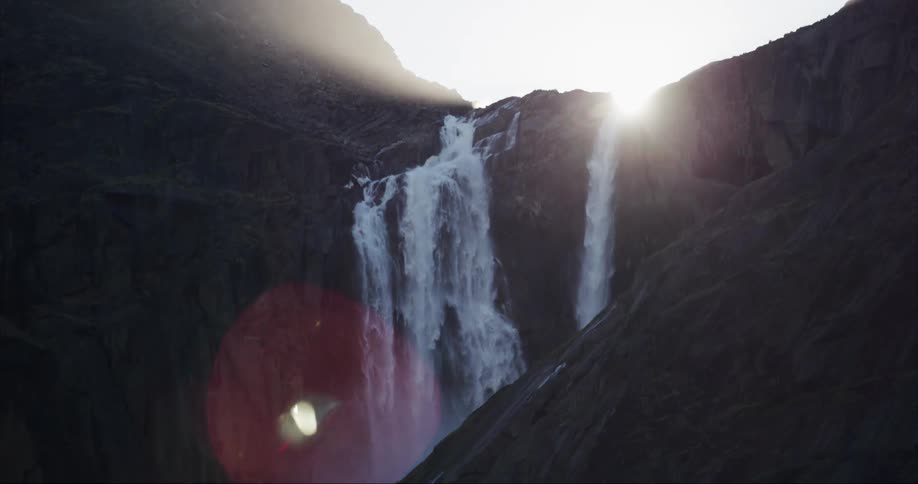 Sunlight blasting through the notch made by a massive waterfall in a granite carved valley similar to Yosemite Falls