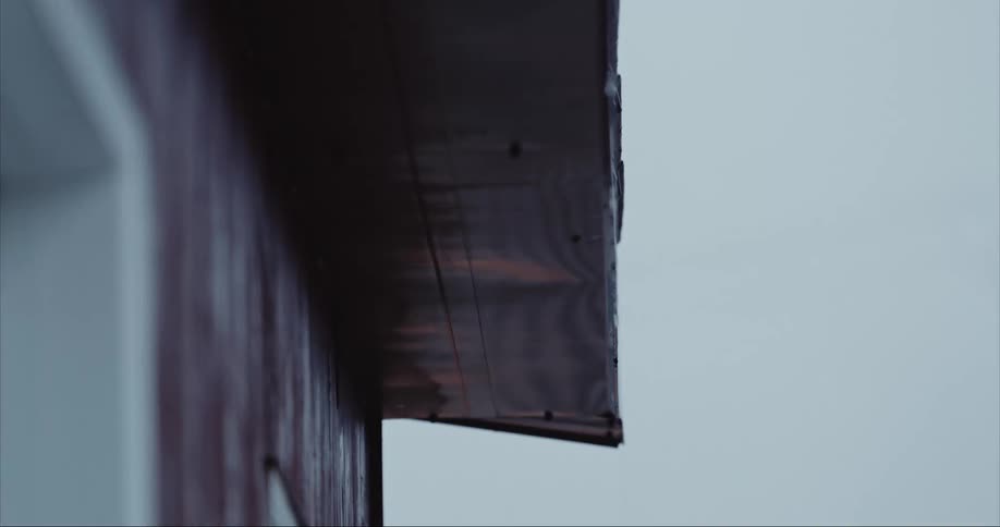 Rain dripping from a wood roof during a rainstorm on Baffin Island