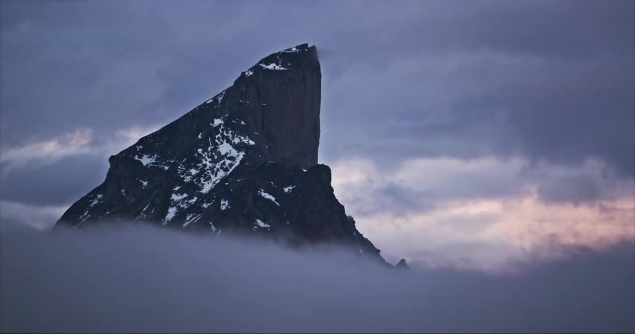 Mount Thor sits proudly as storm clouds swirl around it's base on Baffin Island in Auyuittuq National Park