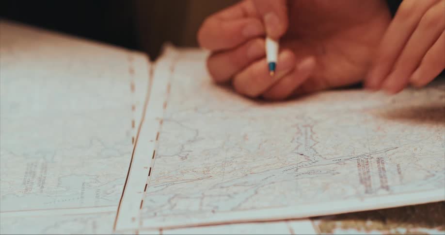 Route finding on Baffin Island as two people chart our path on a topographical map