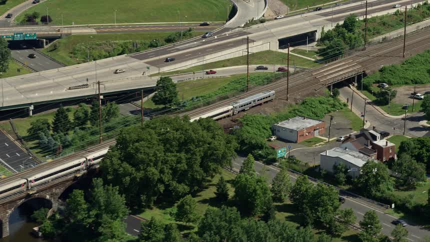 Aerial footage of a commuter train crossing Morrisville-Trenton Railroad Bridge in Trenton New Jersey on a sunny day
