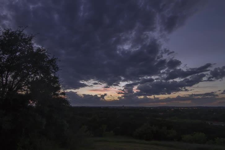 Clouds roll over a vast landscape outside a small urban area
