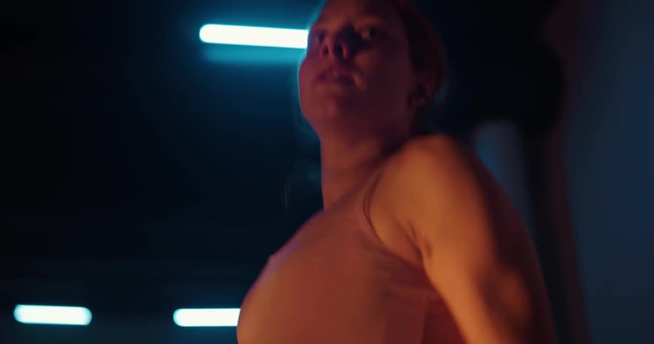 Redhead jumps rope in dimly lit gym