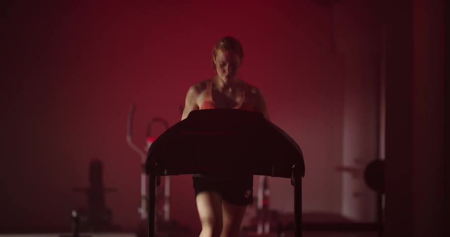 A woman runs on a treadmill at the gym