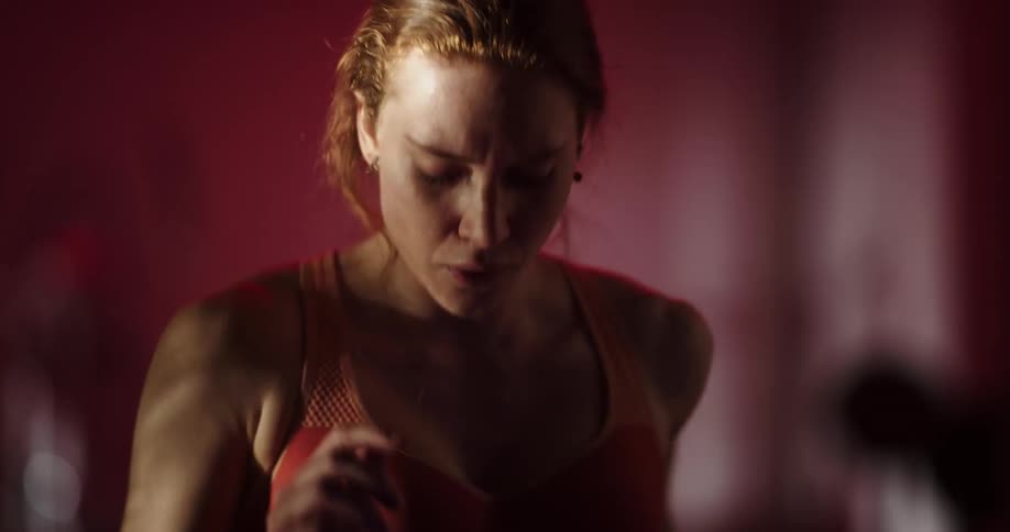 Woman with ponytail and sports bra exercises on treadmill