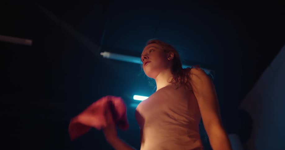 A woman uses a towel to wipe sweat off her face