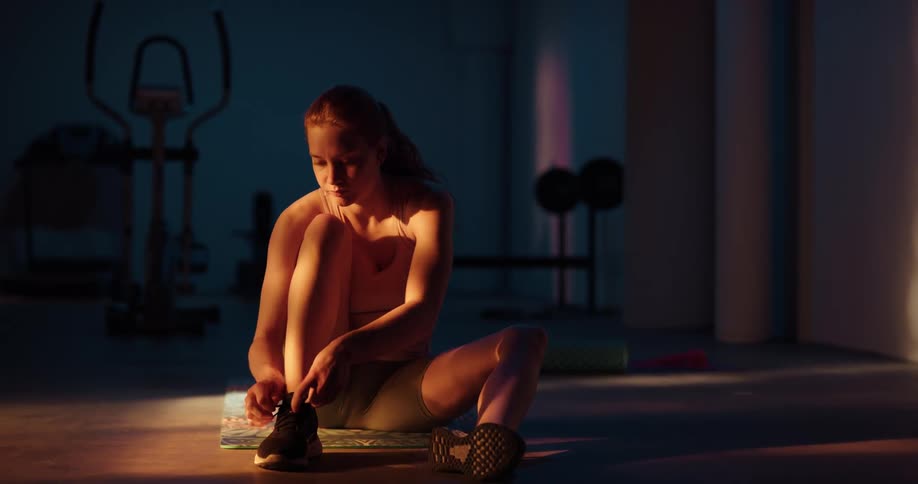 A woman stands up after she finishes tying her shoe
