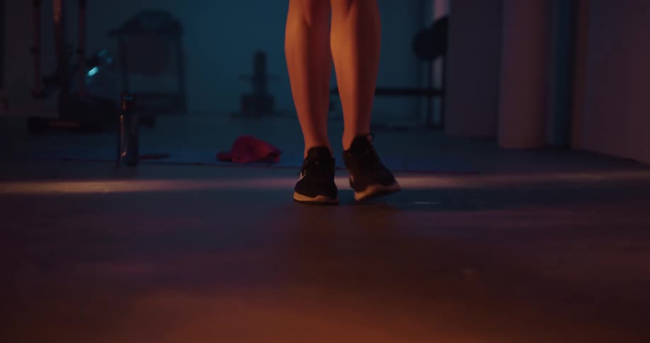 A womans legs and feet are shown jumping over a jump rope several times
