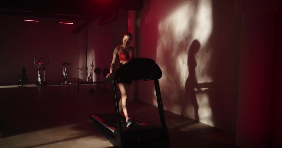 A woman goes from walking to running on a treadmill