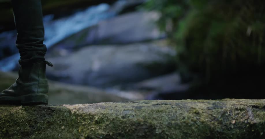 A person hikes over the stream