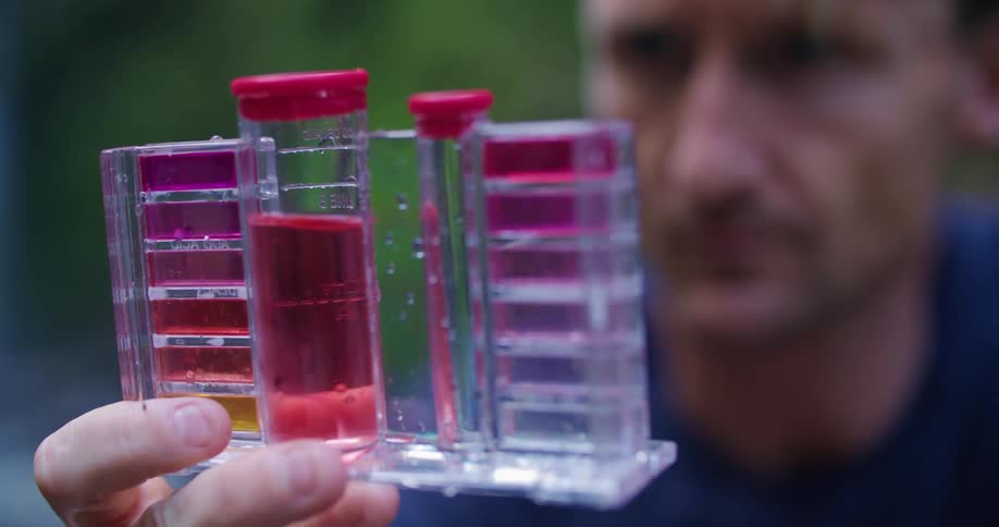 Man in blue shirt holds out test tube