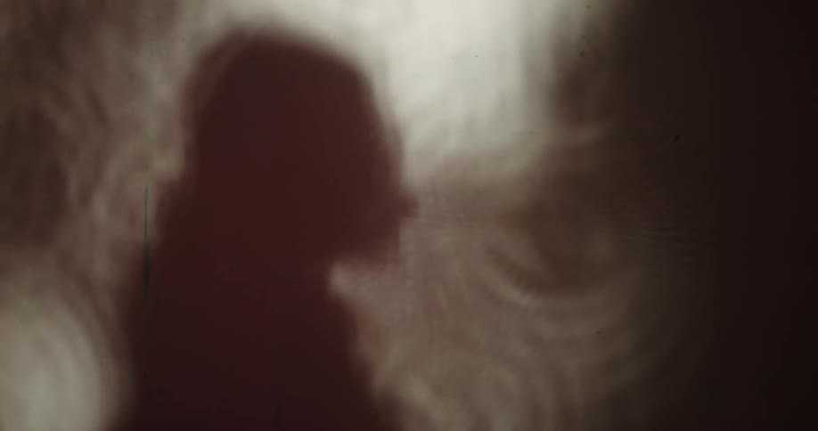 A person in silhouette jogs in place against a textural background