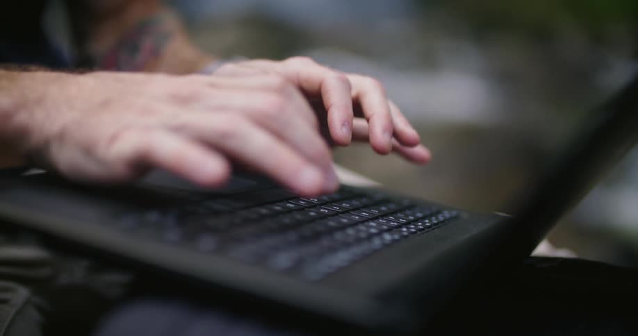 A person is typing on their laptop