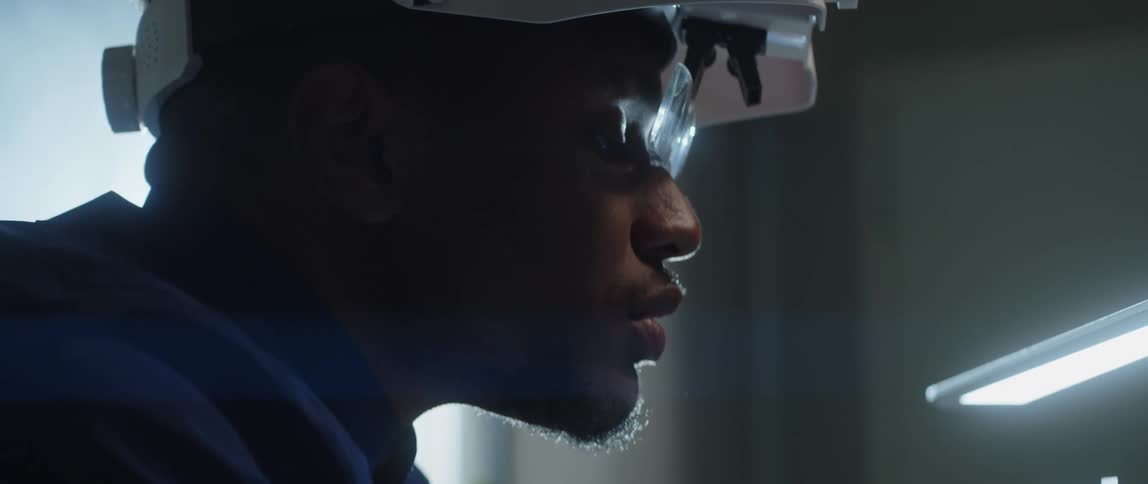 A male worker blowing on a gemstone in a lab