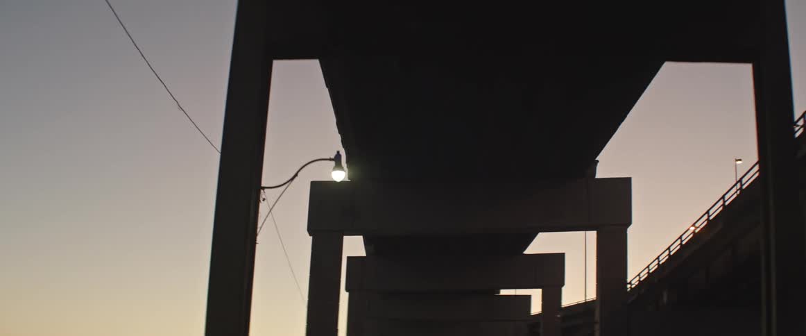A silhouetted overpass in a city at dusk