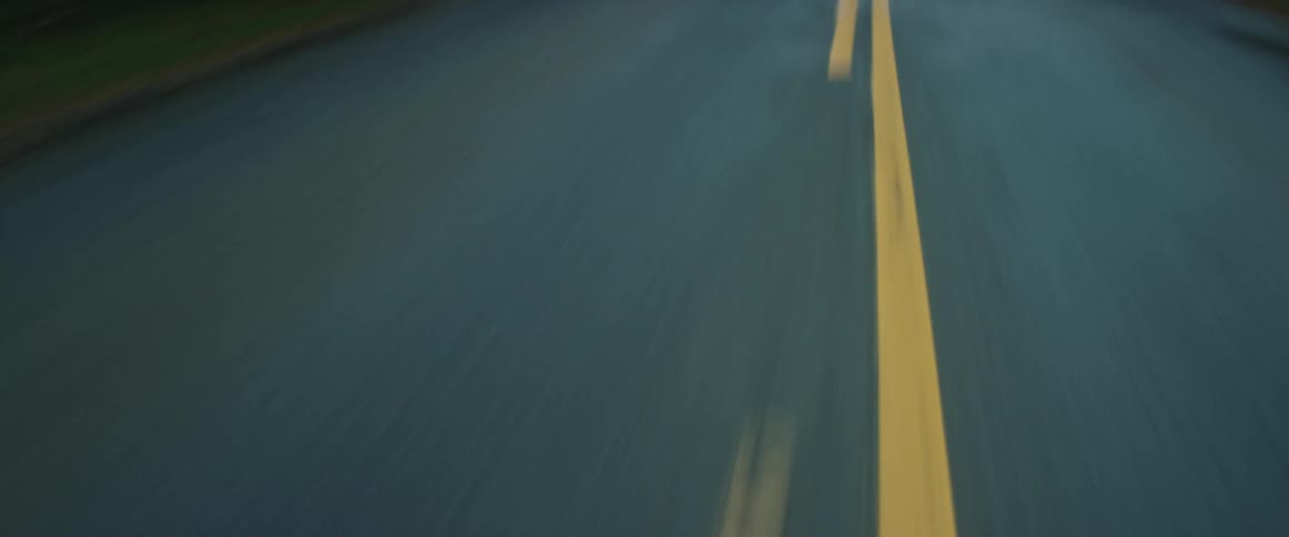 Vehicle drives on highway through the forest