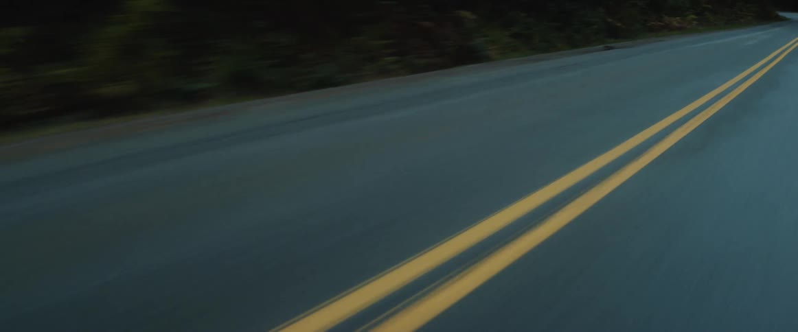 A two lane road curves to the left