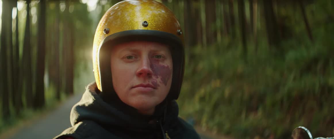 A person is wearing a helmet in a wooded area