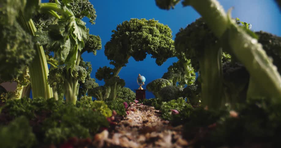 A surreal place with broccoli trees and a globe of the world at the end of a path under a deep blue sky