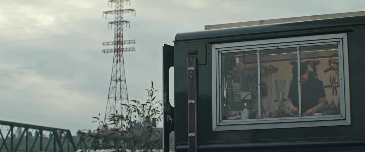 Mechanic wearing black hat and t shirt works in her repair truck using tools