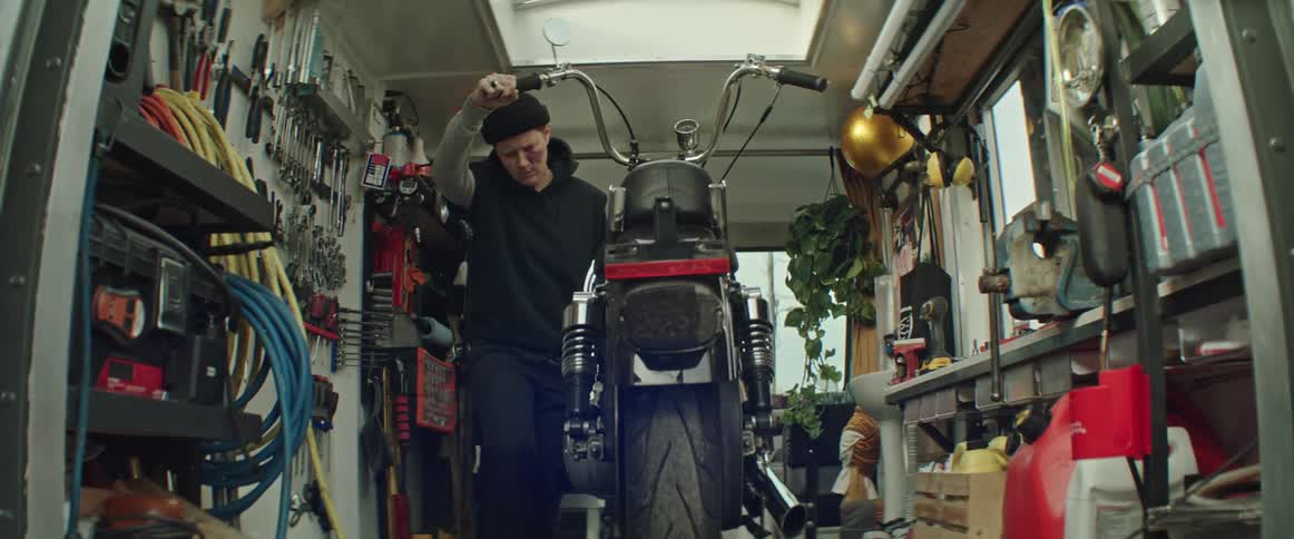 A woman working on a motorcycle in her mobile repair shop