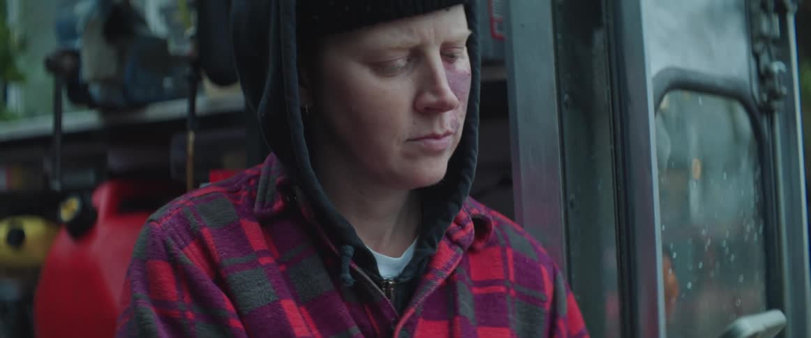 A woman holding their phone and typing while sitting on the back of a truck