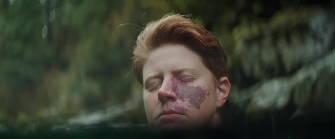 A woman is in a state of meditation while submerged in a mountain river