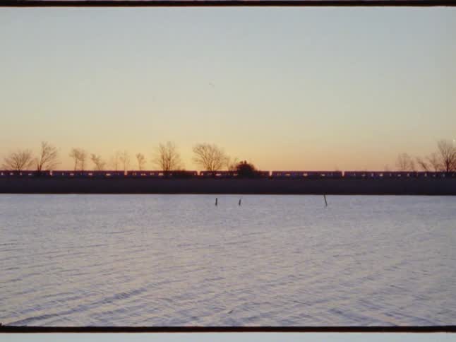 A train going across tracks near a body of water