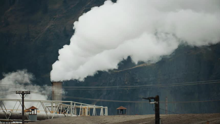 A manufacturing plant releases steam and smoke into the atmosphere on a cold winter day deep in middle america