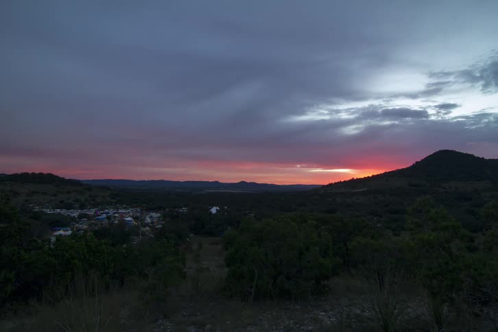 The sun is setting behind the mountain in the distance