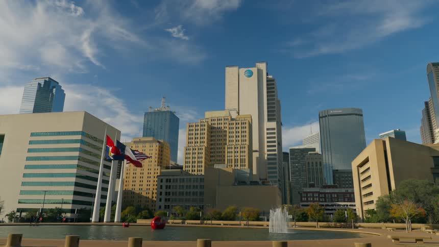 Flags by a fountain in front of office buildings in a city