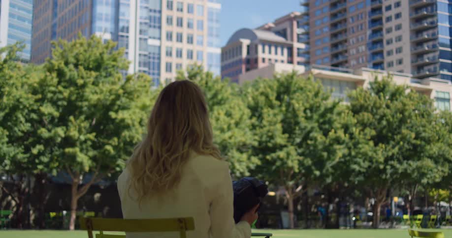 A woman observes the crowd milling in a downtown park